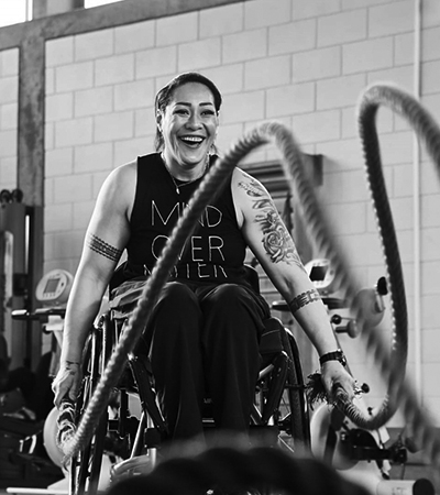 Smiling woman in wheelchair working out at a gym